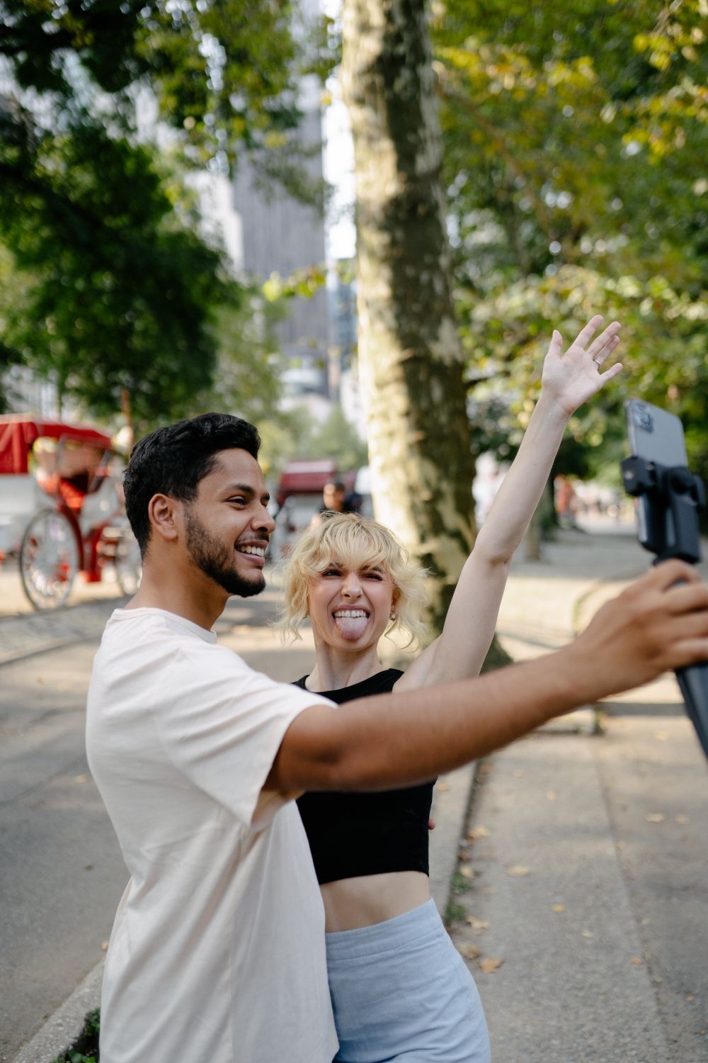 Una pareja se hace un selfie mientras pasea por un parque.